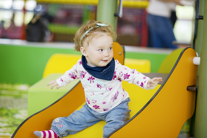 eibe play equipment for the catering industry with laughing girl on a slide.