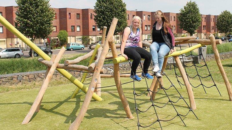 School playground planning - two girls siting on eibe playground equipment in their School playground.