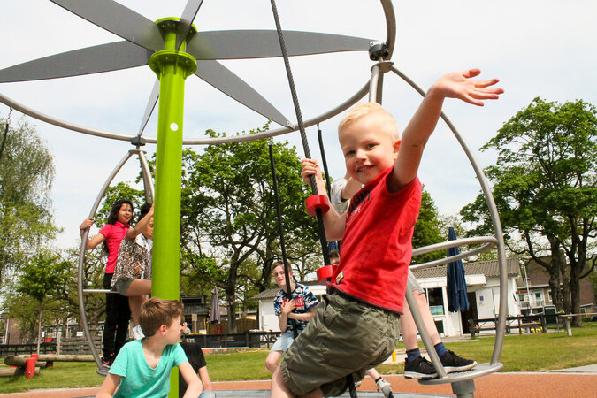 Playground equipment for camping facilities - children playing on a climbing carousel from eibe.